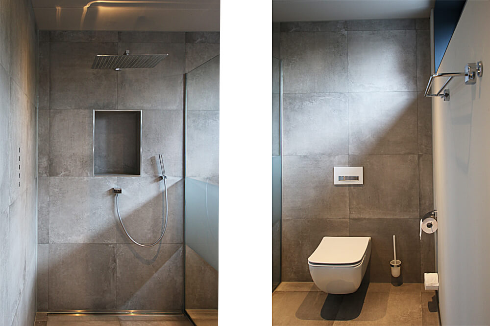 Dusche mit Regenpaneel und Fliesen in Betonoptik / Gefliestes WC in schlichter Betonoptik